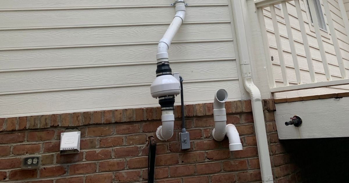 Exterior-mounted radon mitigation fan designed to draw gas from beneath the foundation and vent it safely above the roofline